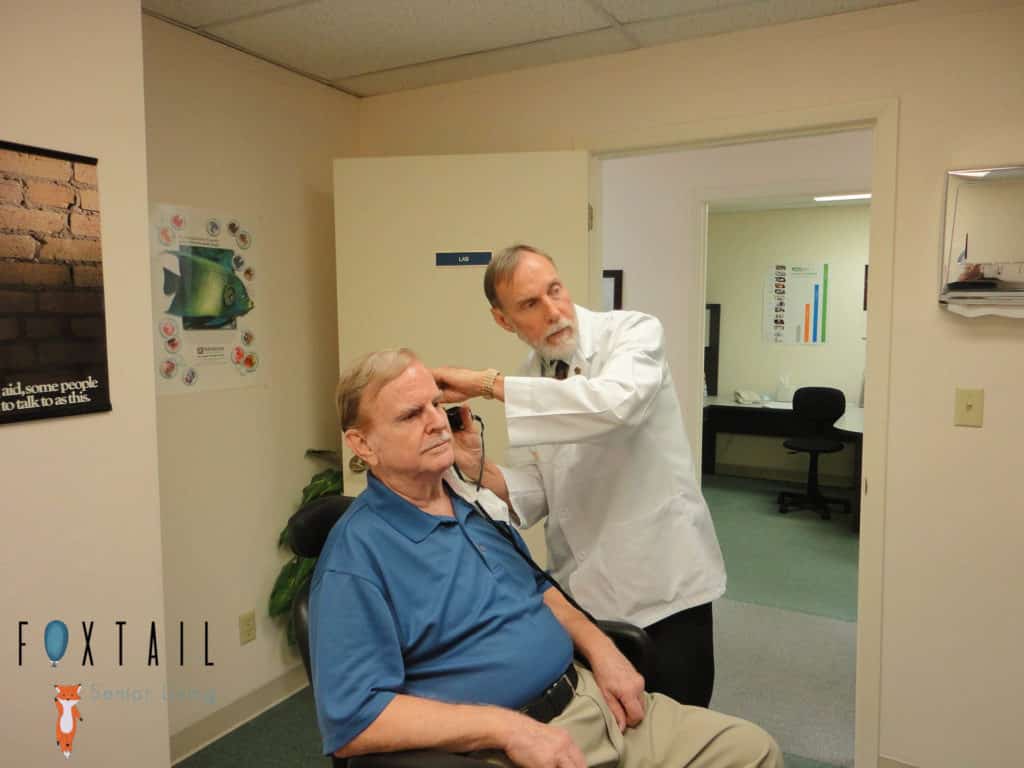 Elderly man getting a hearing test in a doctor’s office.