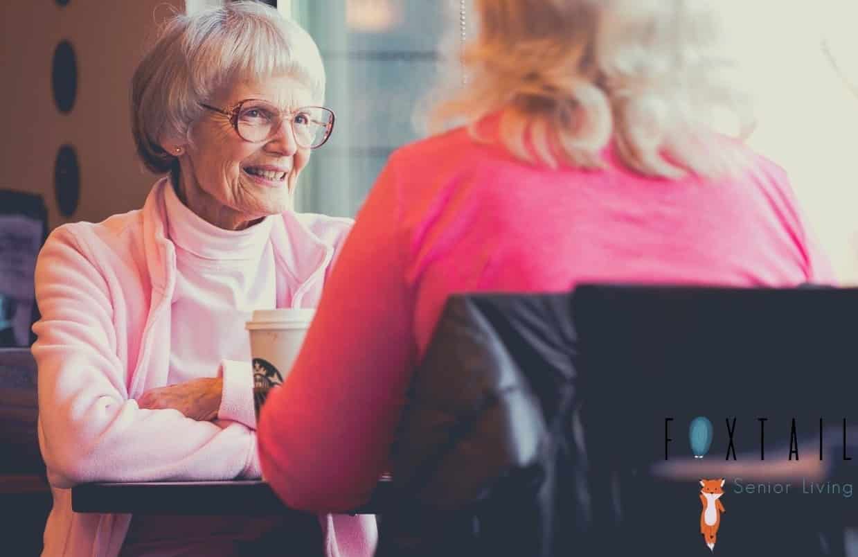Senior woman talking to a friend with coffee