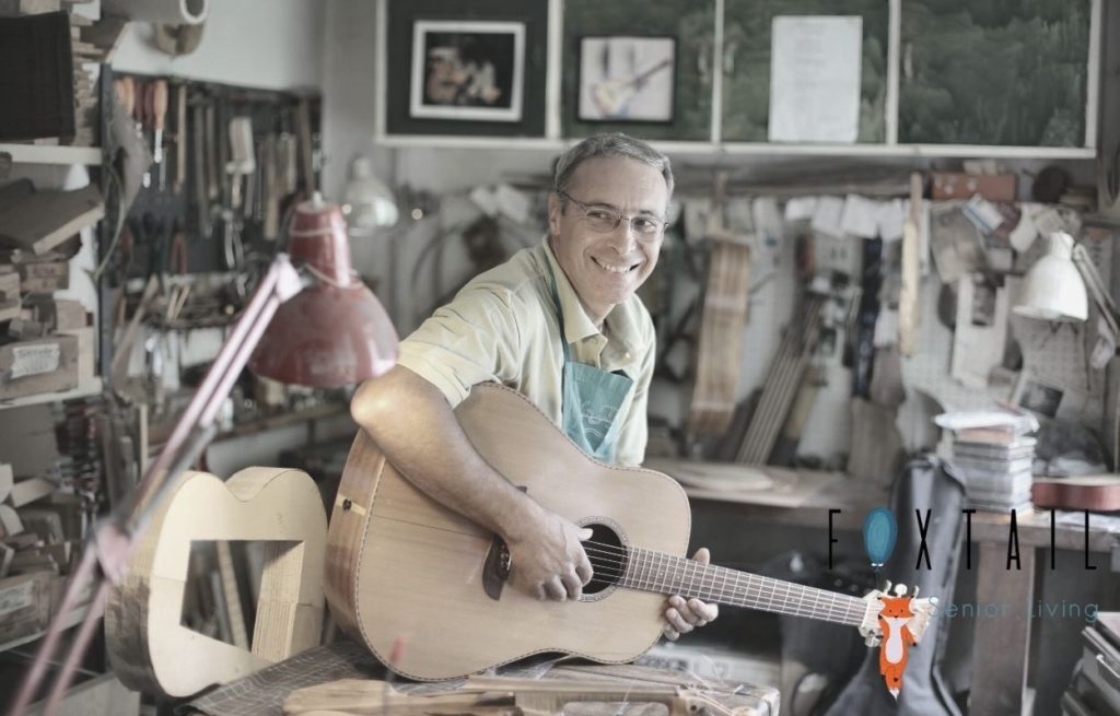 Senior man playing guitar in a workshop