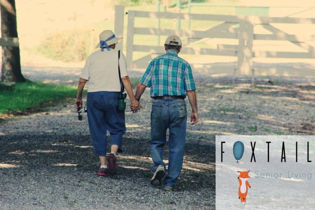 An older couple walking down a gravel road